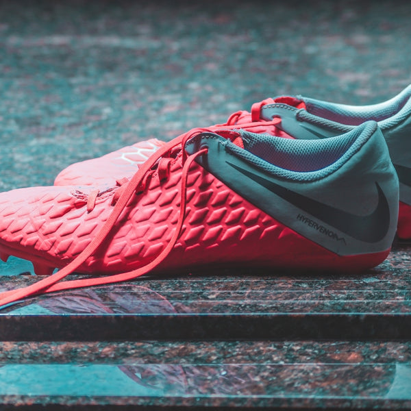 pair of red-and-grey Nike cleats