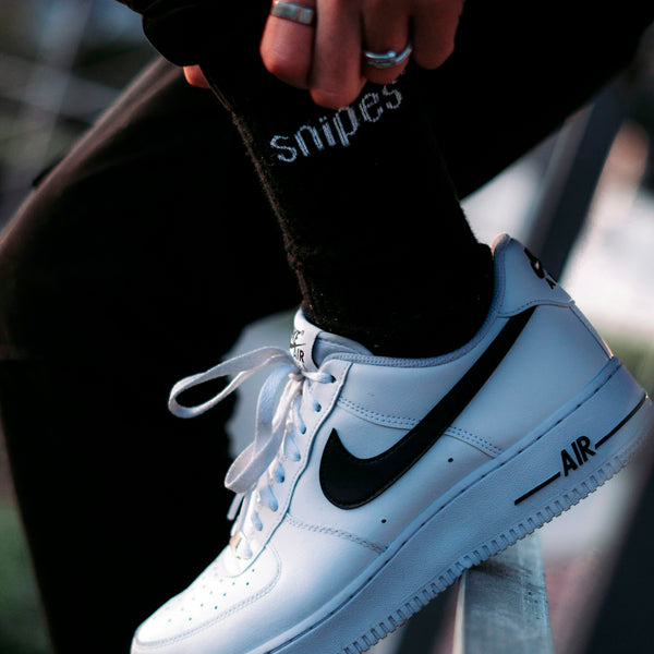 a person wearing a pair of black and white sneakers